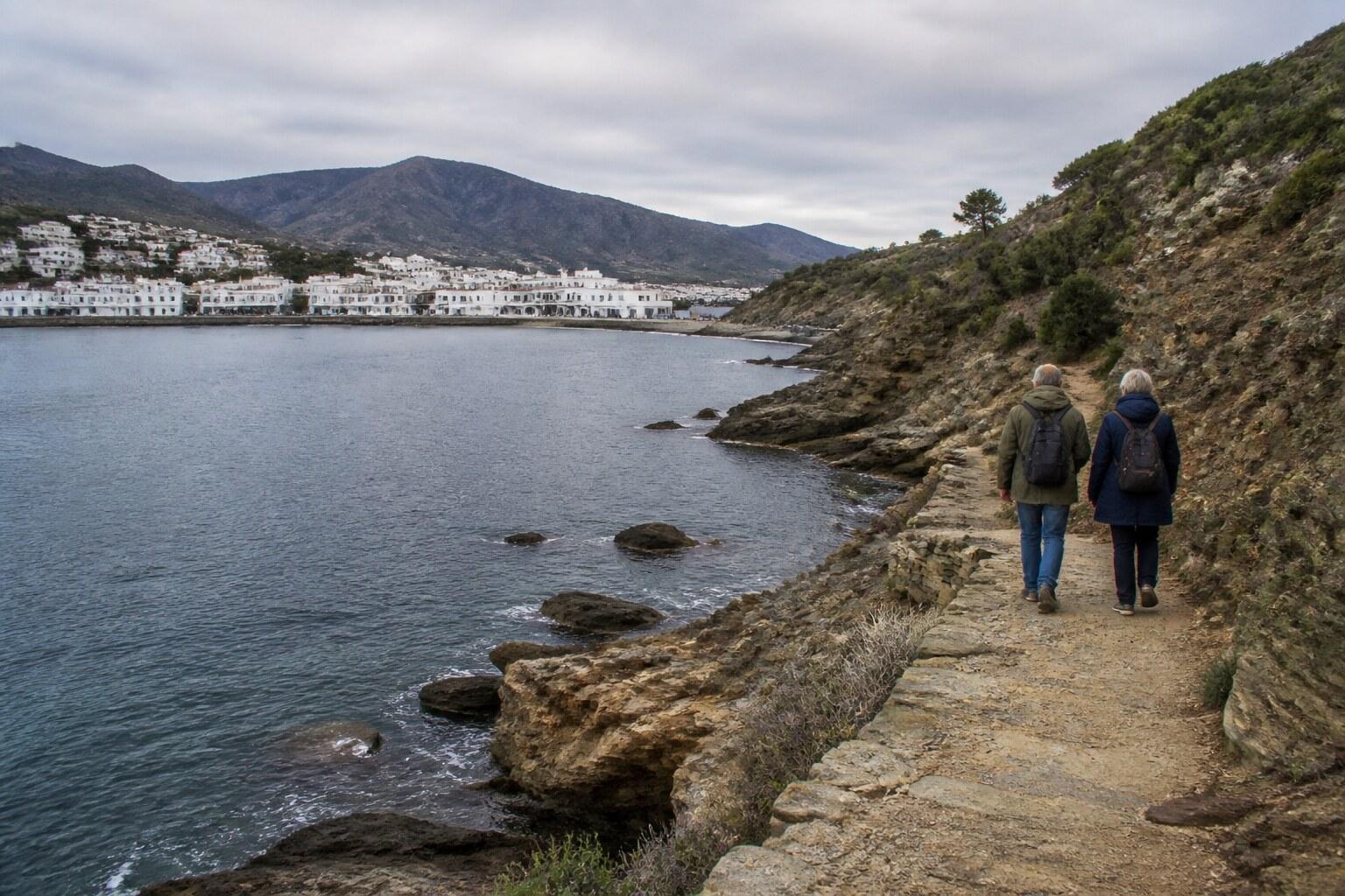 Walker following the empty rocky shore outside Port de la Selva