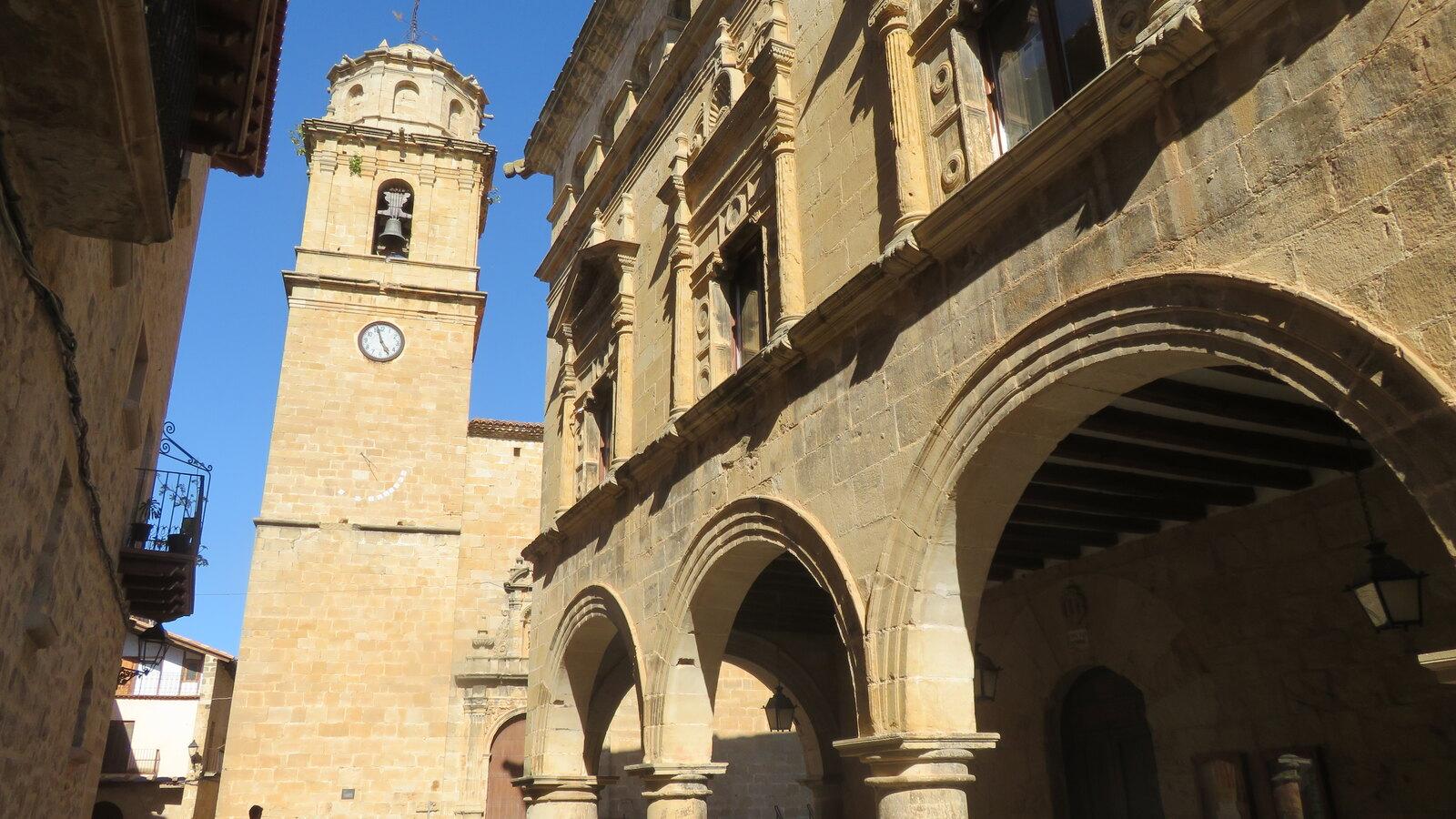 Renaissance arcades of Arnes town hall beside the stone bell tower of Santa Magdalena church